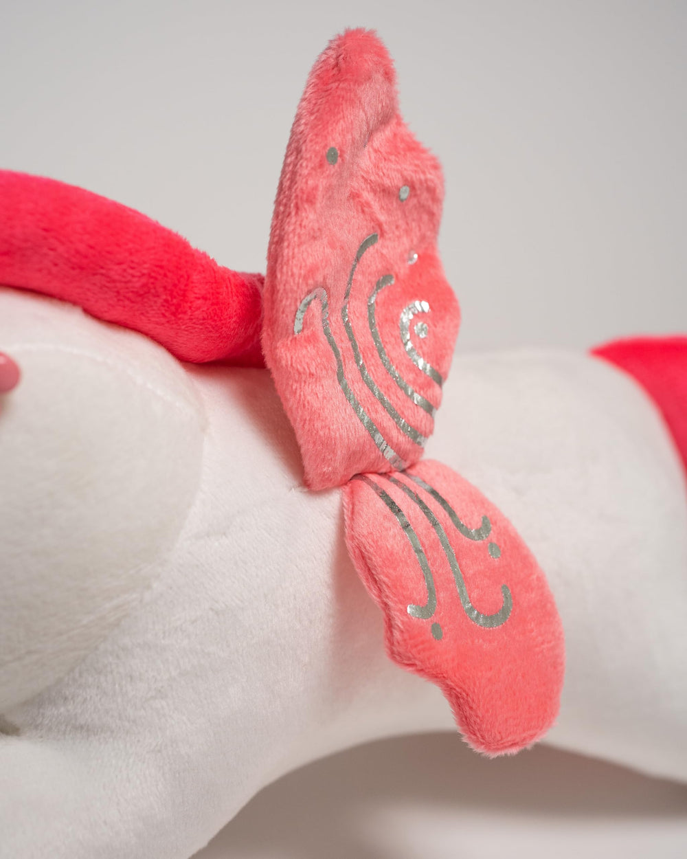 A FOR ADLEY plush has a flower bead above the ear, a cute detail.