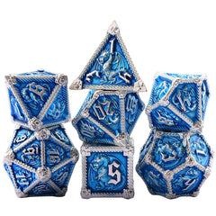 Close-up of AUSTOR dragon engraving on metal dice, showcasing craftsmanship.