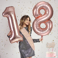 Awfrky rose gold 18-number balloons create a photogenic backdrop.