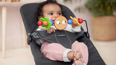 BabyBjörn wooden toy with spinning figures promotes fine motor exploration during playtime.
