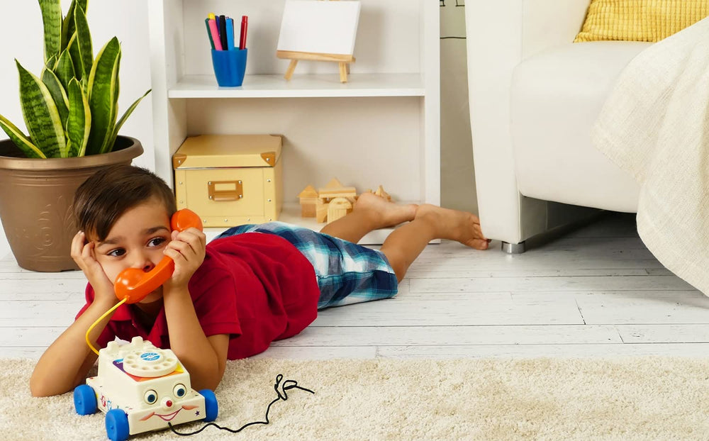 Child pulling the classic Chatter Phone with a friendly face
