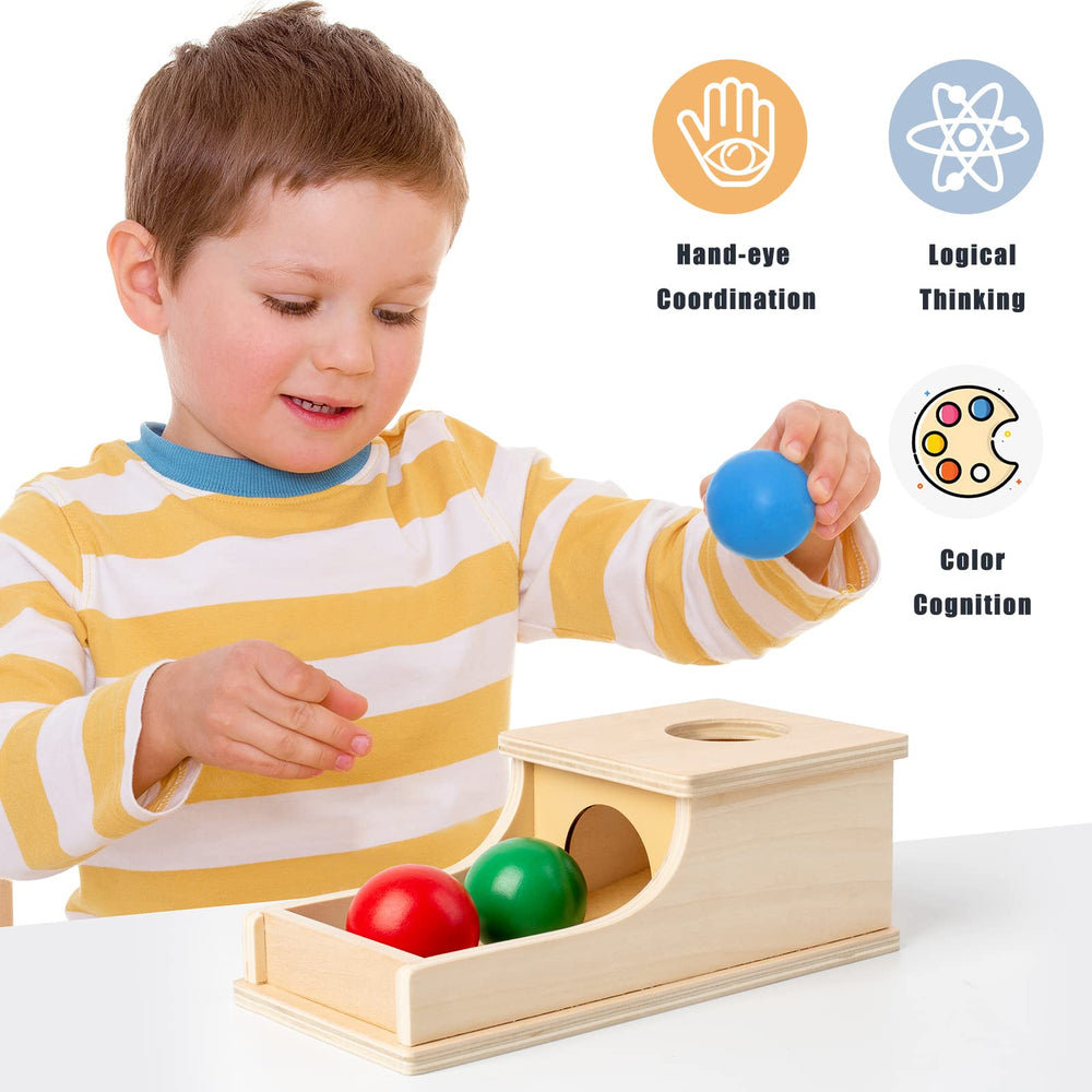Busy edition box with tray demonstrates object permanence through drop-and-find play.