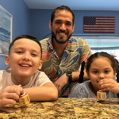 Casa De Queta family spinning pirinola during fun game night.
