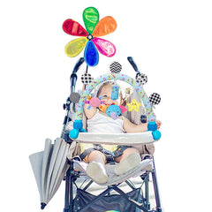 Caterbee pram activity bar with plush toys engages baby outdoors.