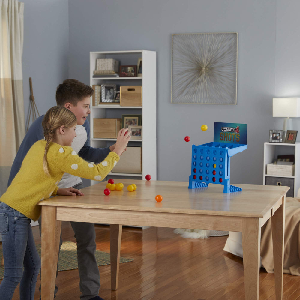 Connect 4 Shots kids playing indoors for active standing-up fun.