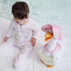 Cuddle Barn Mother Goose holds a book as soft music plays.
