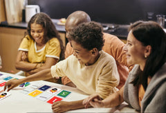 Elimino Family Card Game players around table during a round, promoting family bonding.