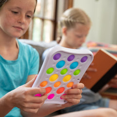 Fat Brain Dimpl Pops compact travel toy for play anywhere.