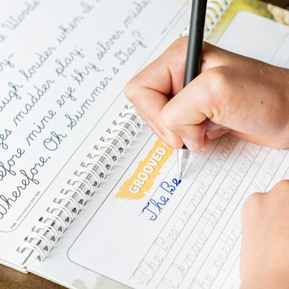 Homeschool desk setup featuring Graceful By Design workbook and supplies.