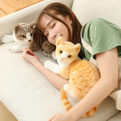 GUDVES orange tabby cat plush in a relaxed sleeping pose.