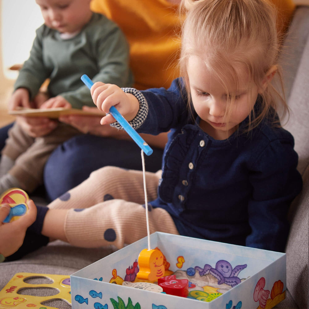 HABA Here Fishy Fishy magnetic fishing game wooden pieces closeup shows sustainable, tactile play components.