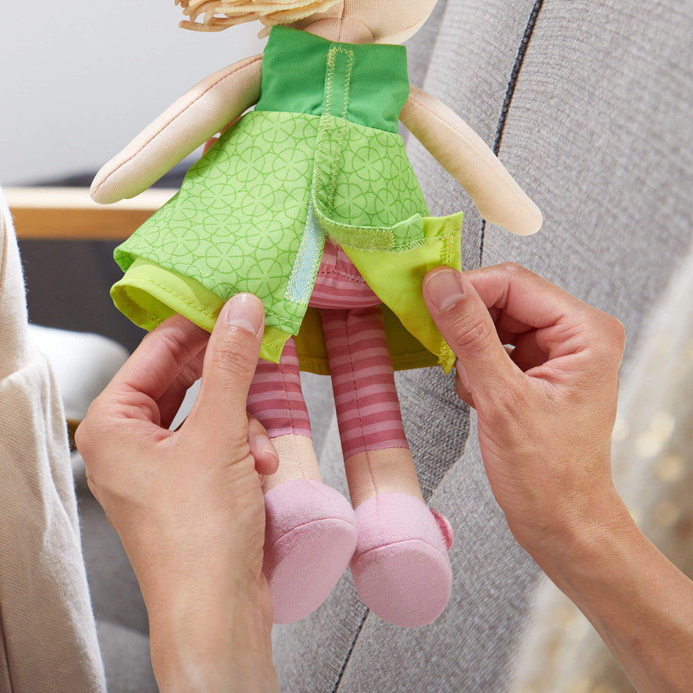 Embroidered-face Mali doll with gentle expression during daily adventures.