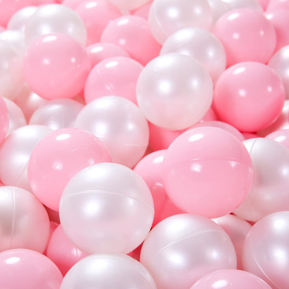 Child playing with Heopeis pink pearl white balls in a ball pit