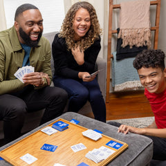 Kids Against Maturity family game night scene with laughing players