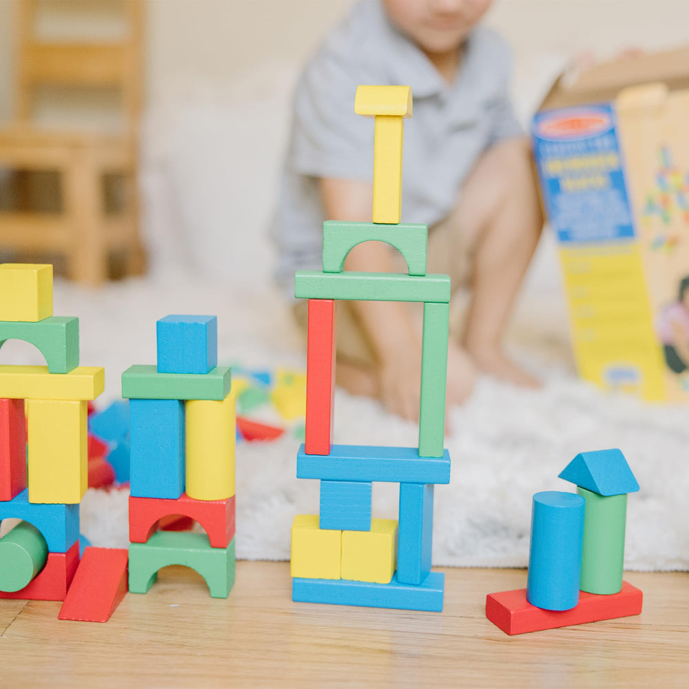 Melissa & Doug hand next to blocks for scale showing child-friendly piece size