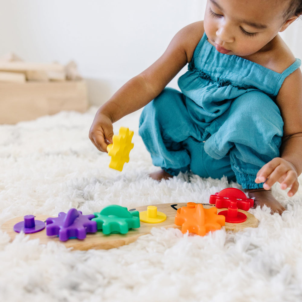 Melissa & Doug Rainbow Caterpillar Gear Toy showing six interchangeable gears in bright colors.