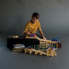 MindWare KEVA Contraptions marble maze demonstrates simple physics with ramps and tunnels.