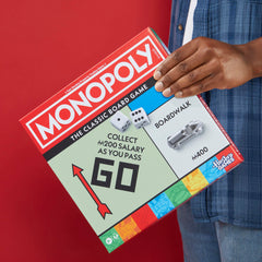 Hand holding a larger token to show scale, Monopoly tokens are easier for kids to handle