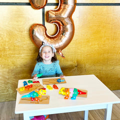 Montessori Mama dinosaur puzzles child playing demonstrates concentration during playtime.