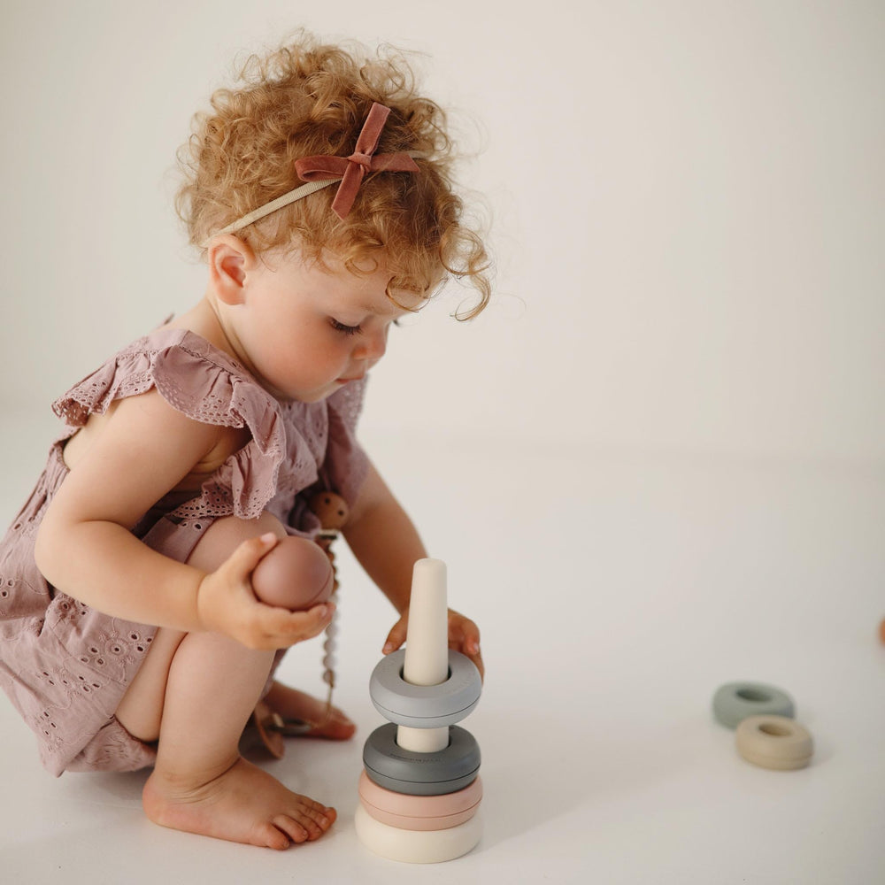 Mushie stacking rings in hand-ready design support grasp and coordination