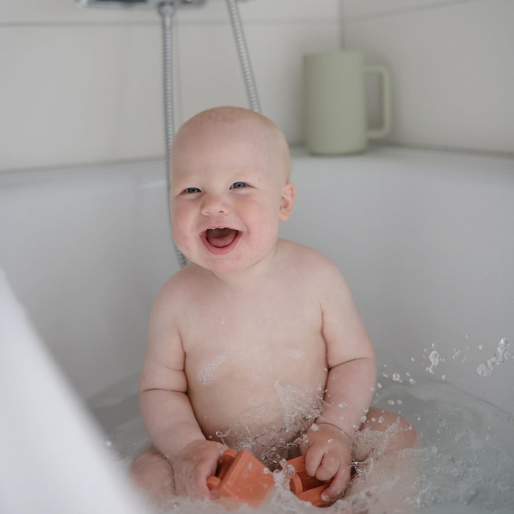 Mushie excavator bath toy: two-piece design for thorough cleaning.