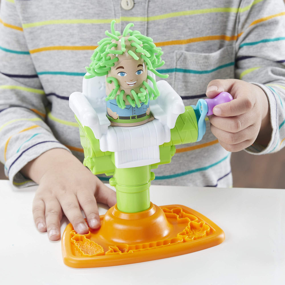 Kids crank to grow Play-Doh hair with Buzz 'n Cut for playful looks.