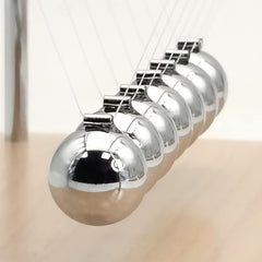 QLKUNLA Newtons Cradle desk setup demonstrates elegance and educational appeal in office.