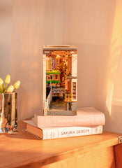 ROBOTIME Sakura Tram LED light adds warm glow to cozy night reading nook.