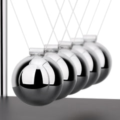 SEVNPRIME Newton's cradle in action demonstrates energy transfer with a relaxing, science-inspired desk focal point.