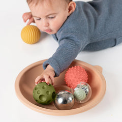 Taf Toys family play scene emphasizes shared sensory exploration between parent and baby.