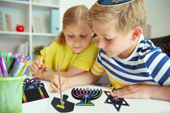 The Dreidel Company scratch card surface is black until scratch reveals color.