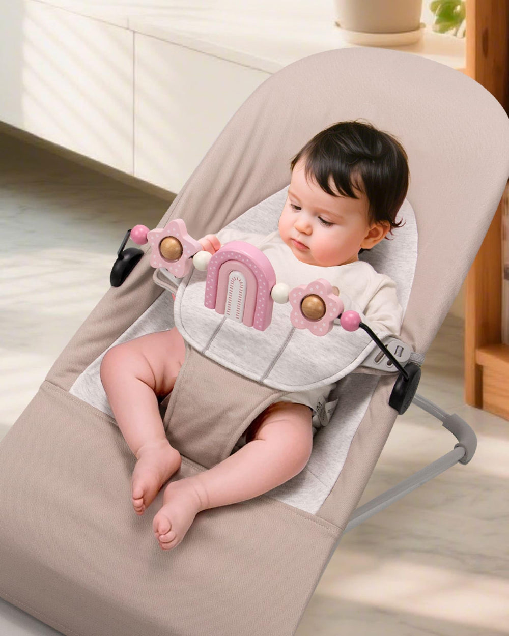 Easy installation view of TinlyFinly toy bar on a compatible bouncer