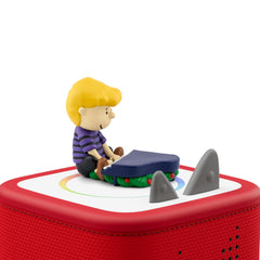 Tonies Peanuts Linus figurine beside a festive playback setup for family singing.