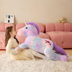 Tumyay cuddly unicorn plush toy on a bed ready for bedtime stories.