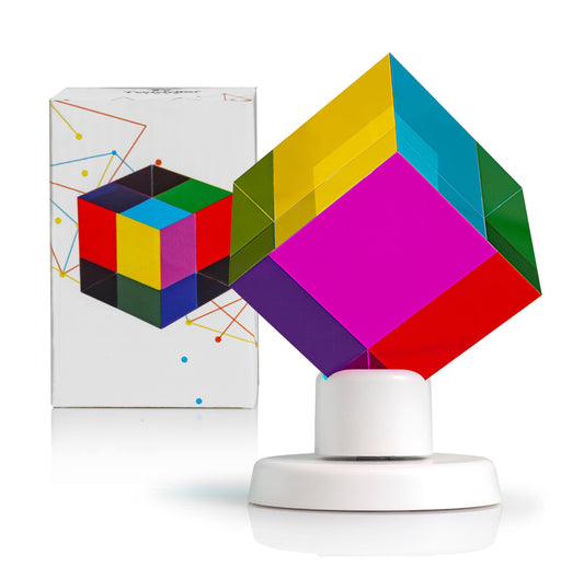 Twiddler Toys color mixing cube on display stand showing vibrant cyan, yellow, and magenta.