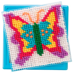 Young crafter displaying a completed ALEX butterfly needlepoint piece