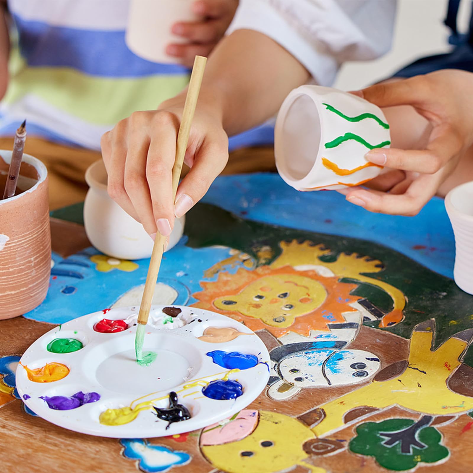 Aujazyble kids crafting in action showcasing colorful, personal pottery pieces.