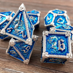 Close-up of D12, D10, D8 metal dice with dragon-inspired design.