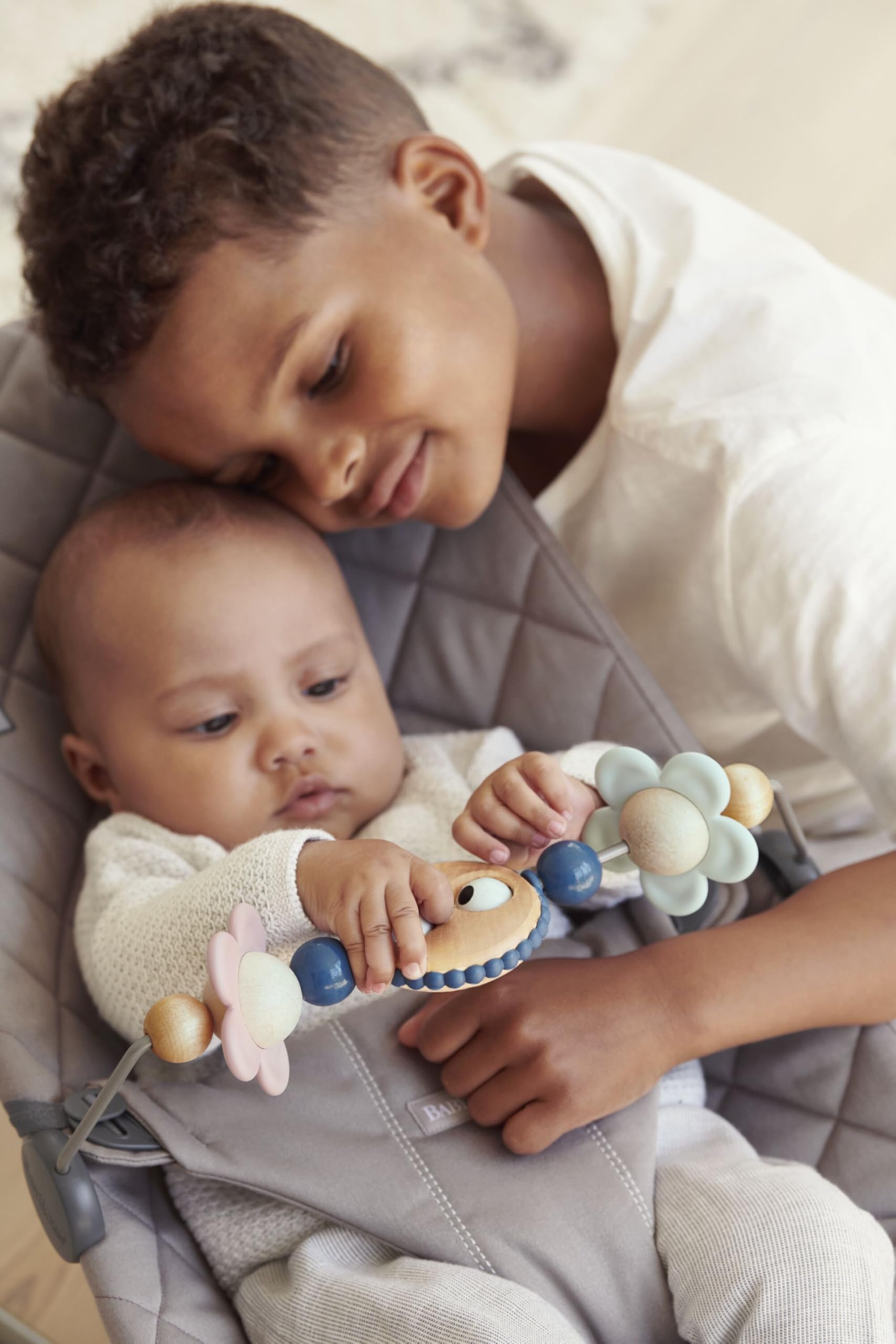 BabyBjörn pastel shapes spin for visual tracking and safe bouncer play.