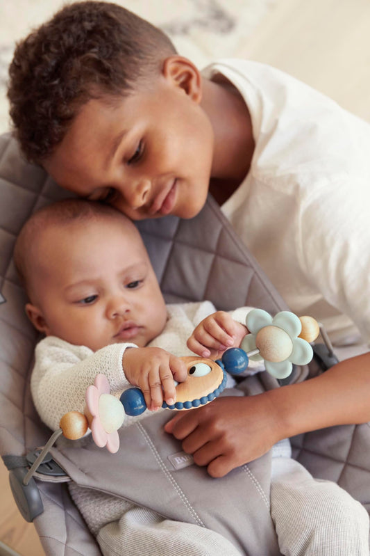 BabyBjörn pastel shapes spin for visual tracking and safe bouncer play.