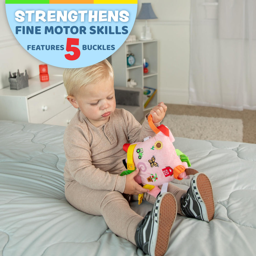 Boink Pig develops fine motor skills through interactive buckles and straps in a plush form