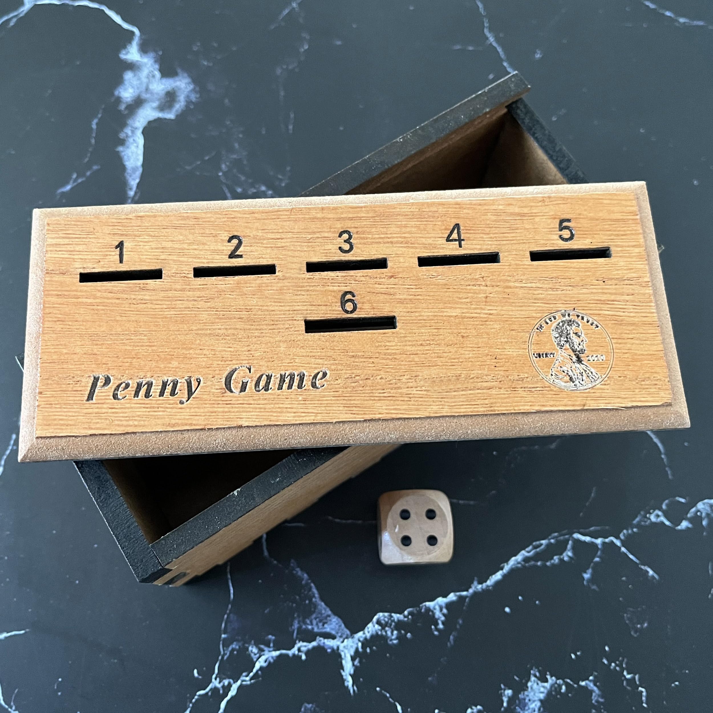 CBLKUS Penny Game box with coins arranged for strategic drops