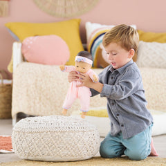 Corolle Bebe Calin Mila wears a pink cap, ready for cozy playtime.