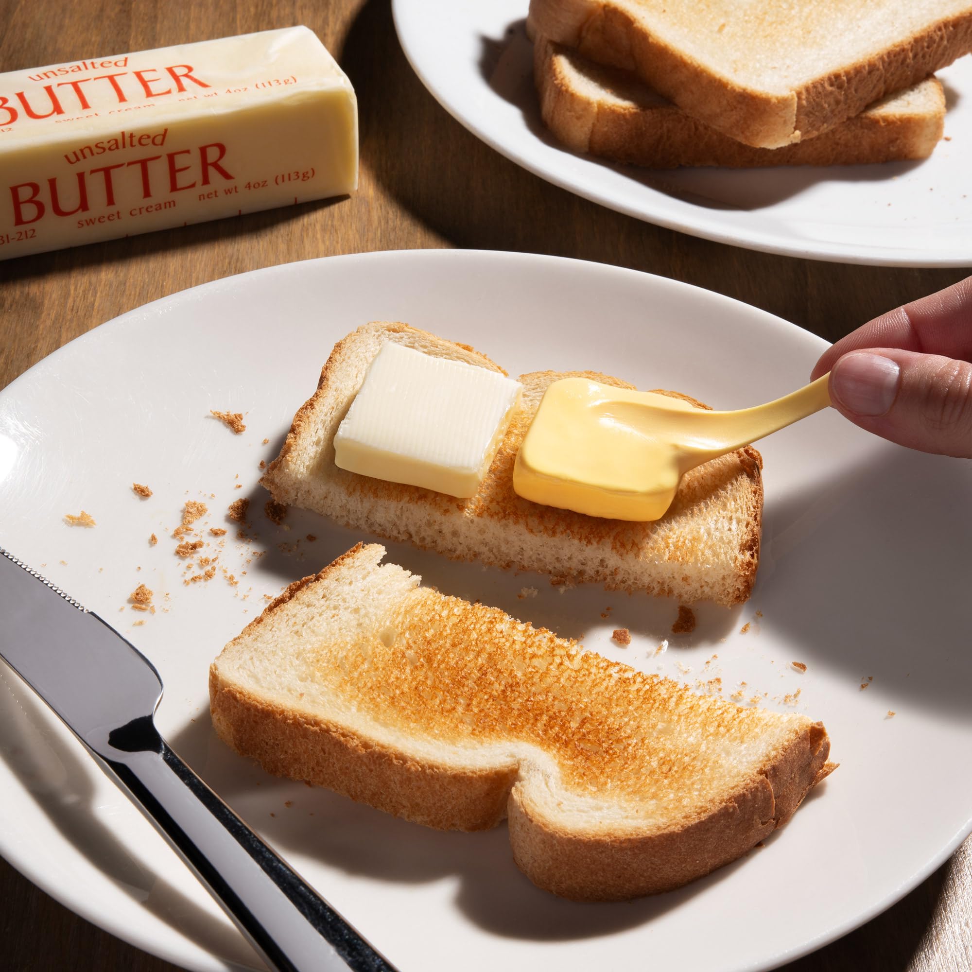 Person fingers gliding through Better Butter Thinking Putty for calming, mindful play at a desk.