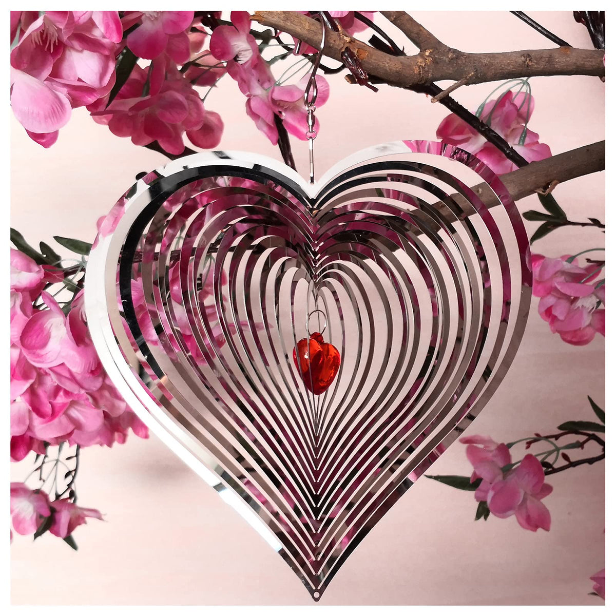 DJUAN wind spinner outdoor metal décor with mirror finish catches sunlight.