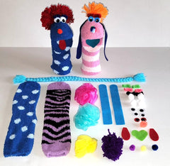 Doopalpoops kit materials spread shows socks, eyes, mouths and hair pieces ready for crafting