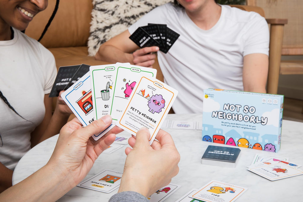 Hands holding Not So Neighborly cards showcasing quick setup.