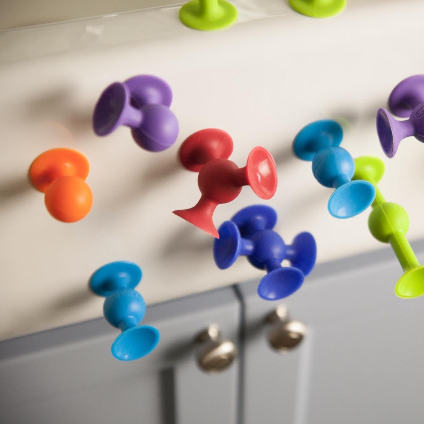Fat Brain Toys Squigz Deluxe pieces stick to smooth surfaces for no-mess play.