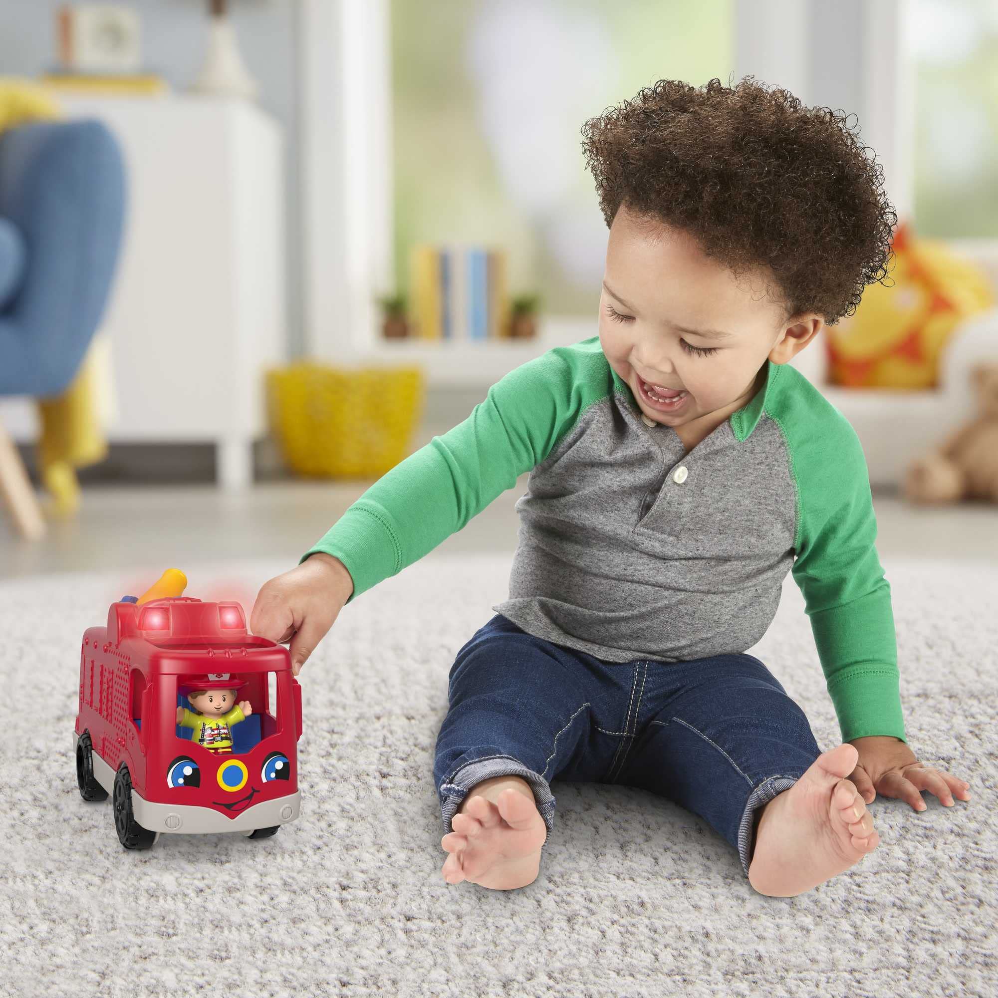 Fisher-Price Little People fire truck driver-seat button triggers sounds and teamwork phrases.
