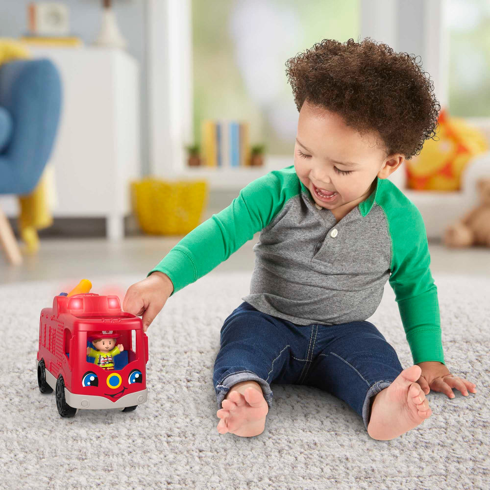 Fisher-Price Little People fire truck driver-seat button triggers sounds and teamwork phrases.